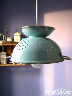 a blue lamp hanging from a ceiling in a room next to a shelf with other items on it