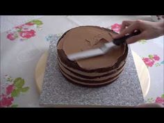 a person cutting into a chocolate cake with a knife