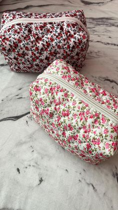 Add a touch of elegance and organization to your daily routine with this charming set of two floral quilted makeup bags. Perfect for storing cosmetics, toiletries, or even small accessories, these bags combine functionality with timeless style. ✨ Features: 1) Beautiful Floral Design:   - Bag 1: Delicate pink flowers with lush green leaves on a crisp white background, exuding a soft and feminine appeal.   - Bag 2: Vibrant red flowers accented by bold black leaves on a light pink backdrop, offerin Floral Makeup Bag Aesthetic, Pink Feminine Rectangular Cosmetic Bag, Floral Pouch Makeup Bags, Floral Toiletry Bag, Quilted Floral Makeup Bag, Pink Backdrop, Pinterest Makeup, Black Leaves, Purse Organization