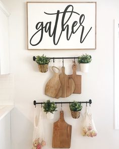 a kitchen wall with cutting boards and potted plants hanging on it's hooks