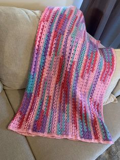 a crocheted blanket sitting on top of a couch