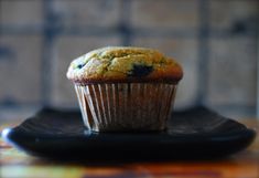 a blueberry muffin sitting on top of a black plate