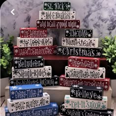 a christmas tree made out of wooden blocks with snowflakes and words on them