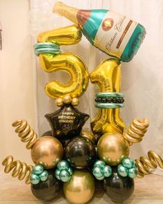 a 50th birthday decoration with balloons and wine bottle in the shape of number fifty five