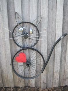 two metal cats made to look like bicycles