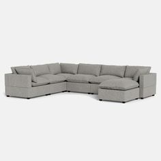 a large sectional couch sitting on top of a white floor next to a gray wall