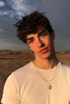 a young man standing in the middle of a desert