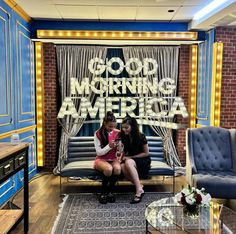 two women sitting on a couch in front of a sign that says good morning america