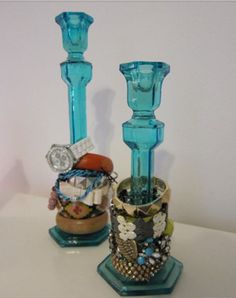 two blue glass candlesticks sitting next to each other on top of a table