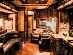 the inside of a motor home with couches, chairs and kitchen in front of it