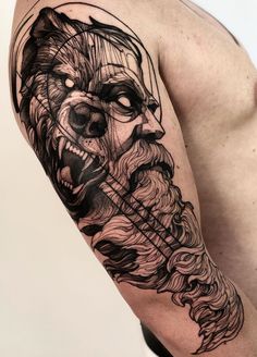 a man's arm with a wolf tattoo on it and an arrow in his mouth