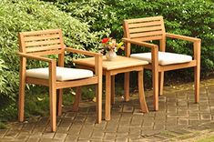 two wooden chairs sitting next to each other on top of a brick floored patio