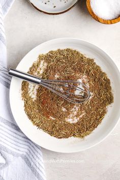 a white bowl filled with spices next to two bowls