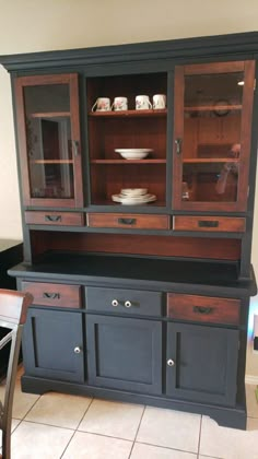 a black china cabinet with glass doors and drawers