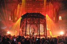 a large group of people standing on top of a stage with bright lights in the background