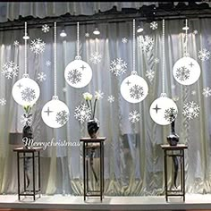 snowflakes are hanging from the ceiling in front of a stage with white curtains