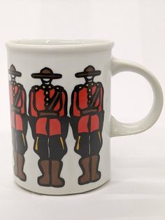 a coffee mug with two soldiers painted on the front and back of it, both in red