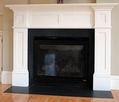 an empty living room with a fireplace and hard wood floors