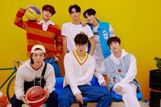 the boys are posing with their basketballs in front of a yellow and blue wall