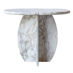 a white marble table with an oval shaped base and two sections on each side that are connected to one another