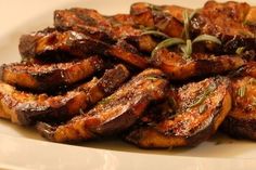 grilled meat on a white plate with herbs