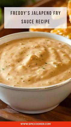 a white bowl filled with sauce sitting on top of a wooden table