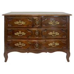 an old wooden dresser with many drawers and gold decorations on the top drawer, against a white background