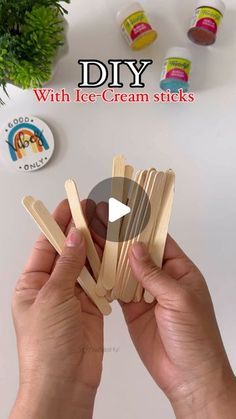 a person is holding wooden sticks with ice cream sticks on them and the words diy above it