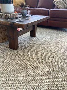 a coffee table sitting on top of a carpeted floor next to a brown couch