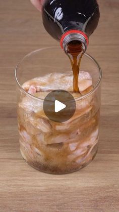 someone pouring sauce into a glass filled with food