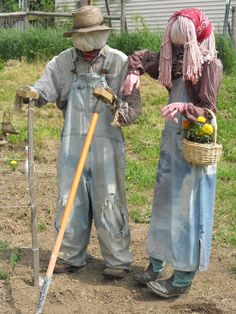 two scarecrows are standing in the dirt