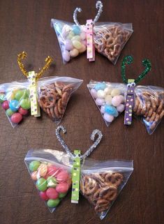 four bags filled with different types of candies and pretzels on top of a table