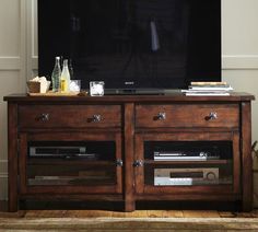 a flat screen tv sitting on top of a wooden entertainment center