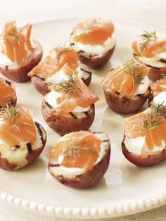 small appetizers with smoked salmon and cream cheese are on a white platter