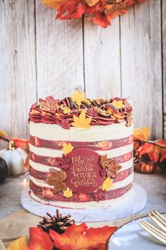 a decorated cake sitting on top of a table next to plates and silver wares