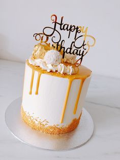 a birthday cake decorated with gold and white icing