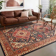 a living room filled with furniture and rugs on top of a hard wood floor