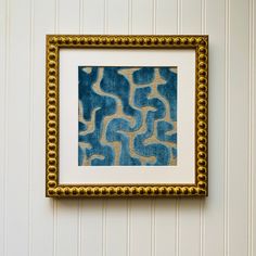 a blue and yellow painting hanging on the wall next to a white striped wallpaper