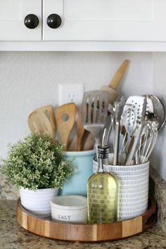 kitchen utensils and spoons are arranged in a tray on the counter top