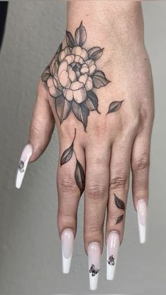 a woman's hand with flowers and leaves on it