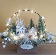 a christmas display with white and green decorations in a circle on top of a wooden table