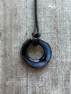 a black and blue necklace hanging on a wooden surface