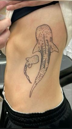 a woman's stomach with a tattoo design on the side of her lower back