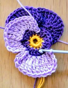 a crocheted flower is being worked on