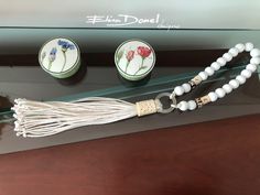 three pieces of jewelry sitting on top of a glass shelf next to other items in front of a sign