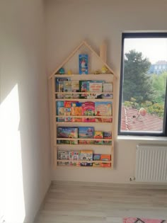 a child's playroom with bookshelves and toys on the floor in front of a window