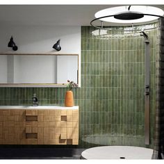 a bathroom with green tiles on the wall and wooden cabinet in the shower stall area