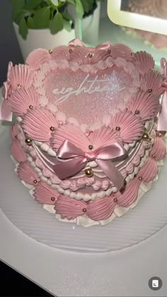 a pink heart shaped cake on top of a white plate