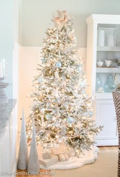 a white christmas tree with blue and silver ornaments