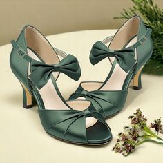 a pair of women's green high heeled shoes with bows on the side